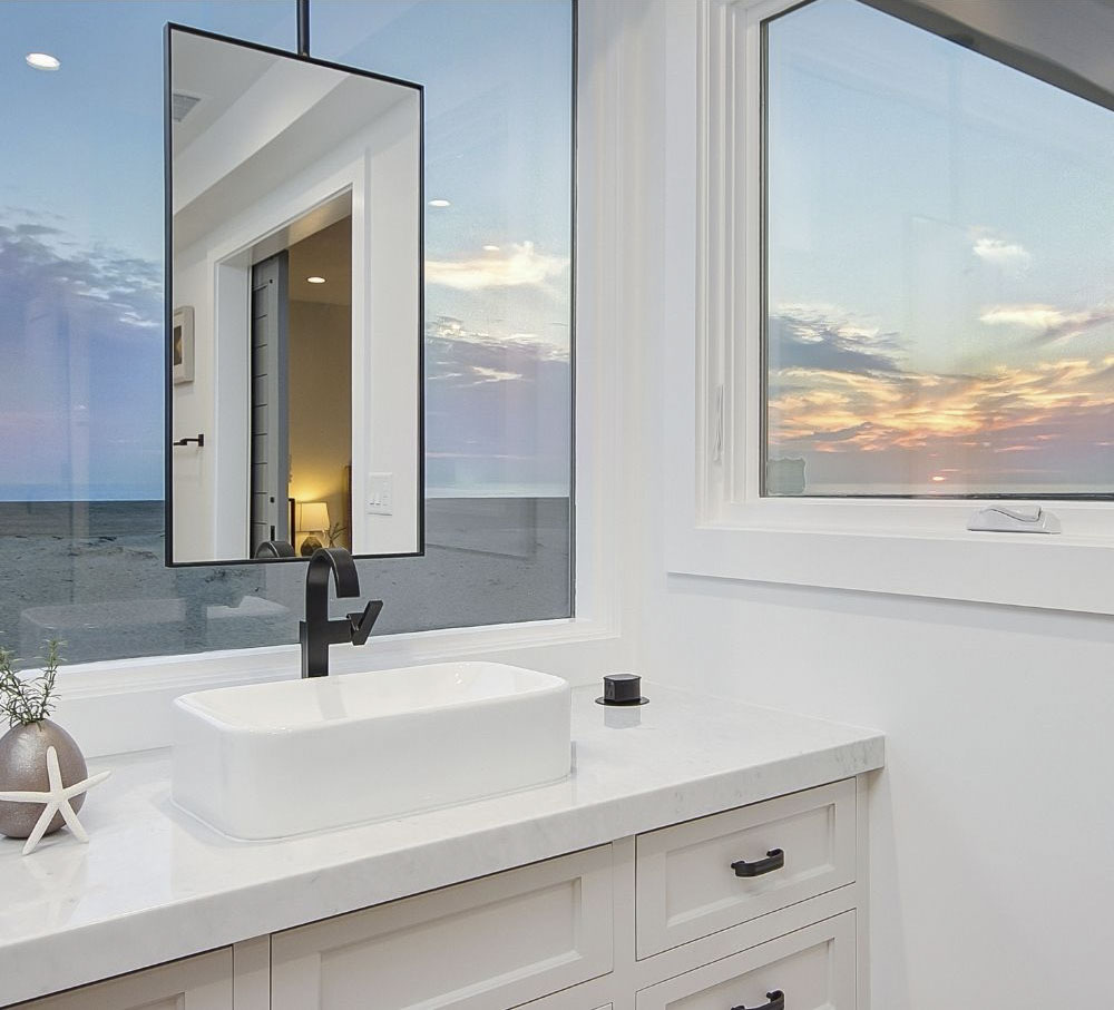 bathroom mirror with view of sunset and ocean